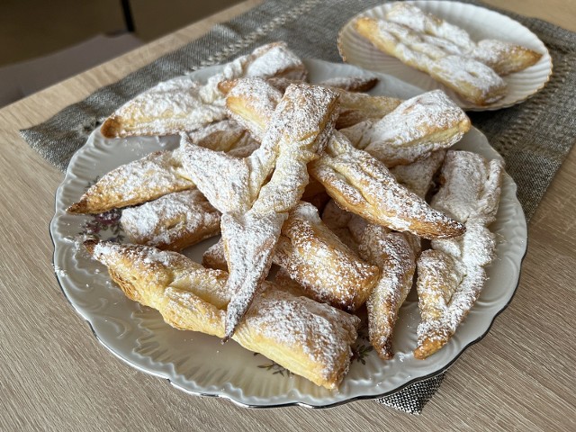 Pyszne chrupiące faworki z ciasta francuskiego, pieczone w piekarniku. Kliknij galerię i zobacz, jak je przygotować. Przesuwaj zdjęcia strzałkami lub gestem.