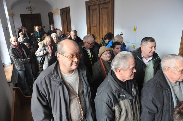 Byli pracownicy Rzeszowskich Zakładów Graficznych SA przed salą sądową czekają na ogłoszenie wyroku na czterech oskarżonych o wyprowadzenie majątku zakładu.