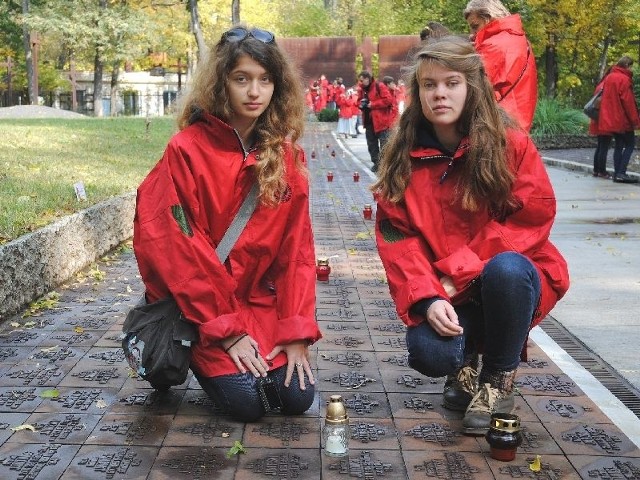 Kazimierskie gimnazjalistki &#8211; Zuzanna Kletschka (z lewej) i Karolina Zachariasz na cmentarzu w Charkowie zapaliły znicze na tabliczkach z nazwiskami oficerów pochodzących z Topoli i ze Skalbmierza.