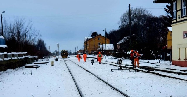 Pracownicy kolei idą pomóc pasażerom.