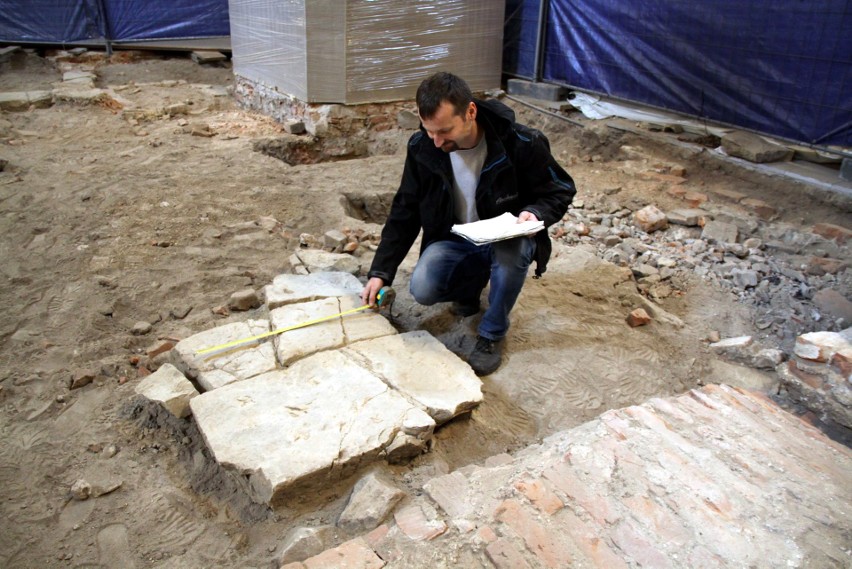 Archeolog Jacek Tkaczyk pokazuje fragmenty dawnej posadzki,...