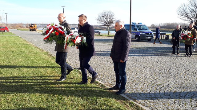 od lewej: Paweł Niedźwiedź, wiceburmistrz Sandomierza, Marcin Piwnik sandomierski starosta, Andrzej Swajda, sekretarz z  sandomierskiego Starostwa składają kwiaty przed pamiątkową tablicą.