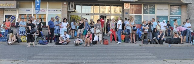Podróżni czekają pod dworcem PKP w Słupsku.