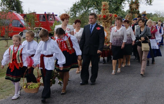 Barwny korowód na czele ze starostami dożynek podąża z wieńcami na mszę świętą.