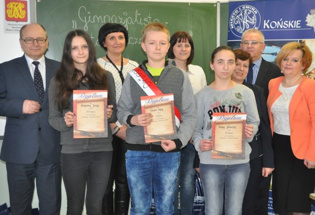 Laureaci konkursu Kacper Wojna, Martyna Gotowicka i Magdalena Jarząb z organizatorkami konkursu Izą Garbacz, Ewą Cecką i Edytą Skawińską, wicedyrektor szkoły w Rogowie  Beatą Gawrońską, burmistrzem Krzysztofem Obratańskim i jego zastępcą Krzysztofem Jasińskim