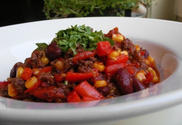 Chili con carne można wzbogacić o ryż lub drobno pokrojone ziemniaki i podać je posypane startym żółtym serem.