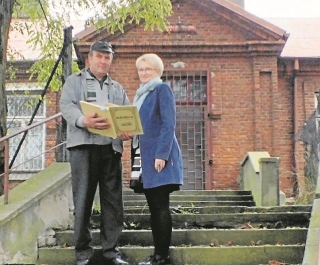 Marian Kujszczyk z Marzeną Urban - Żelazowską, wójtem gminy Sadowie, oglądają prze dawną szkołą pamiętnik Gustawa Maja.