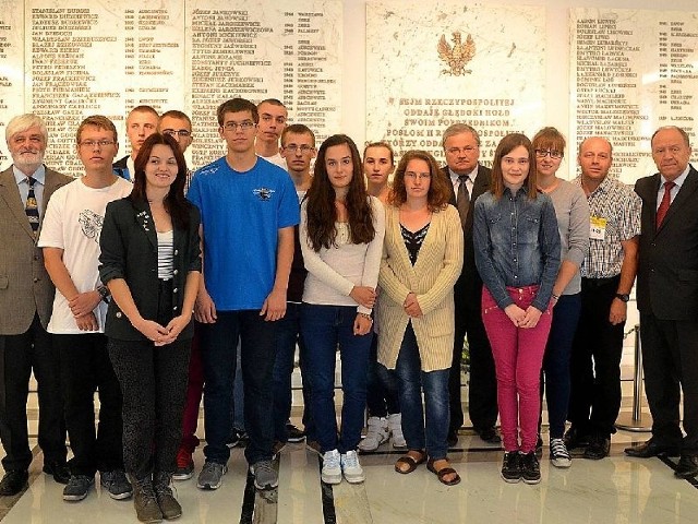 Uczniowie z powiatu niżańskiego przy pamiątkowej tablicy w budynku głównym Sejmu.