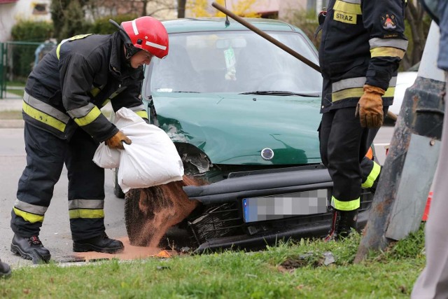 Neutralizowanie płynów, jakie wyciekły z auta po zderzeniu z lampą.