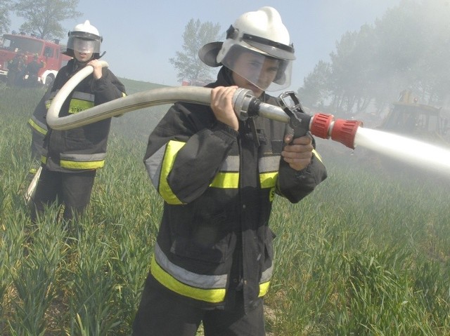 Strażacy podczas akcji gaszenia płonących traw.