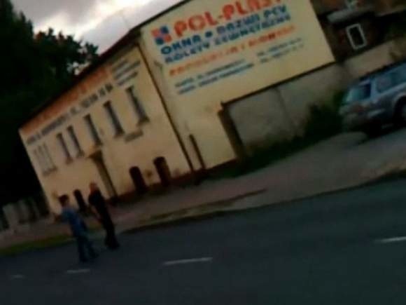 Kadry z filmu słupszczanina. Widać, jak policjant z towarzyszącą mu kobietą przechodzą przez ulicę Przemysłową. Za przechodzenie mniej więcej w tym miejscu nasz czytelnik dostał wcześniej mandat.