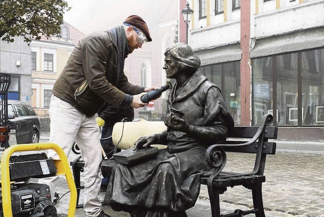 Toruński rzeźbiarz Maciej Jagodziński-Jagenmeer podczas montażu pomnika na grudziądzkim rynku
