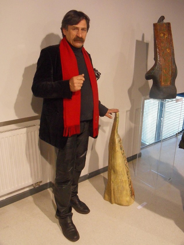 Jacek Szpak przy swoich rzeźbach na wystawie w Warszawie.