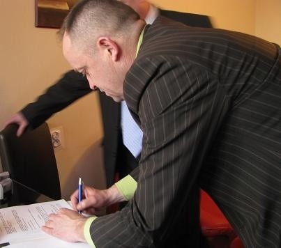 Prezes Narwi Ostrołęka Roman Wargulewski składa podpis na umowie z firmą WALKRYS