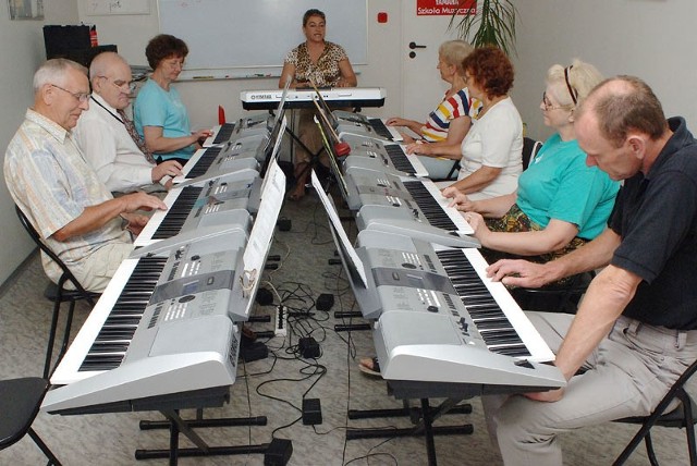 Warsztaty w Szkole Muzycznej YAMAHA. Seniorzy uczą się gry na keyboardzie. 