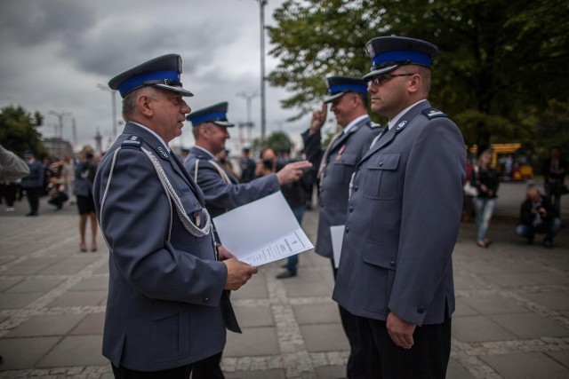 Insp. Dariusz Banachowicz, komendant wojewódzki policji w Łodzi (z lewej), wręcza funkcjonariuszowi nominację na wyższy stopień służbowy podczas Święta Policji w 2013 r.