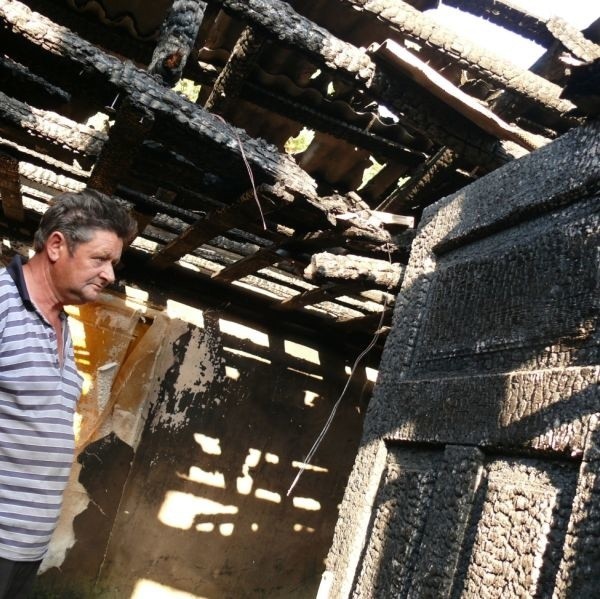 Jerzy Rybiński w wypalonym wnętrzu domu.
