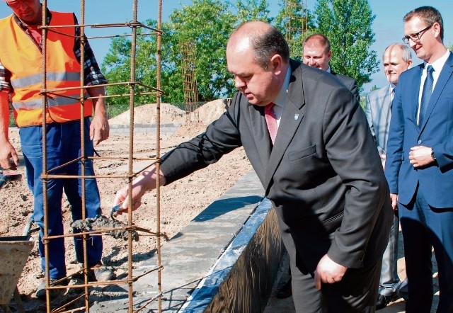Wmurowanie aktu erekcyjnego w fundamenty nowej sali gimnastycznej - z kielnią burmistrz Sławomir Bykowski.