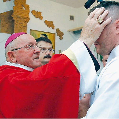 Biskup Tadeusz Werno podczas udzielania więźniom sakramentu bierzmowania.