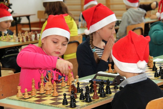 Dzieciaki na mikołajkowym szachowym turnieju miały na głowach mikołajkowe czapki, które otrzymały od sponsora.