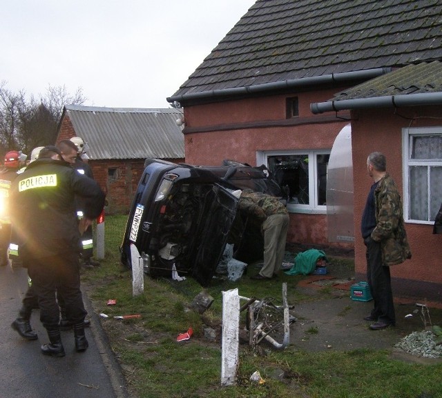 Auto nim uderzyło w ścianę, ścięło płot i przekoziołkowało