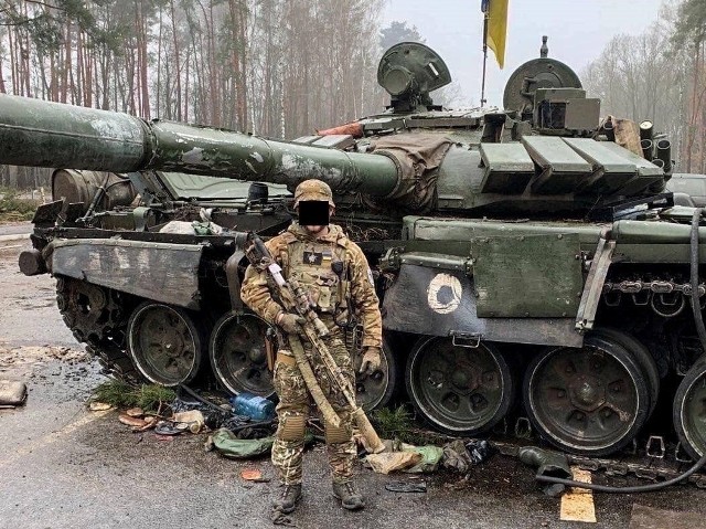 Jeden z obrońców Ukrainy przy rosyjskim zdobytym czołgu