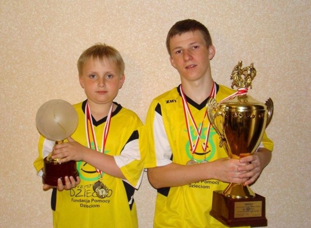 Dwaj zawodnicy drużyny z Daleszyc - Kuba Woźniak (z lewej) i Grzegorz Kozak - z medalami i pucharami wywalczonym w Warszawie.