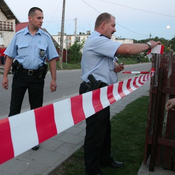 Policjanci zamykają taśmami ulicę na której doszło do zbrodni. Na trasie ucieczki nożownika są jeszcze ślady krwi.