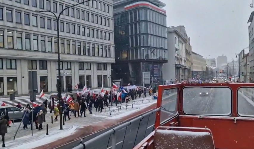 Tłumy ludzi z biało-czerwonymi flagami zmierzają pod Sejm