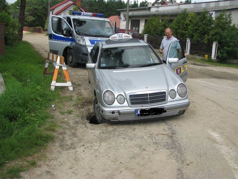 Pod osobówką zapadł się asfalt. Samochód ugrzązł w dziurze (zdjęcia)