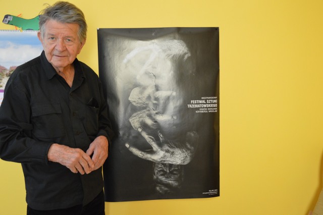 Janusz Trzebiatowski zaprasza na Dni Sztuki. W głębi plakat promujący Międzynarodowy Festiwal Sztuki Trzebiatowskiego.