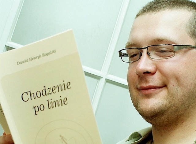 Na zdjęciu Dawid Rogalski i jego najnowszy tomik "Chodzenie po linie"