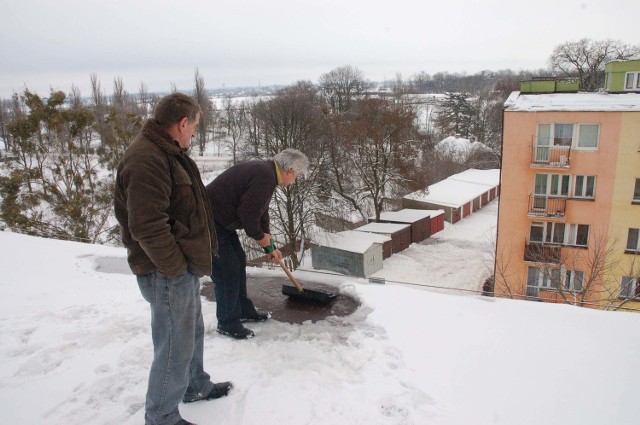 Na dachu bloku na osiedlu Skarpa próbuje usuwać śnieg i wodę zalewającą mieszkania Paweł Urbanek.