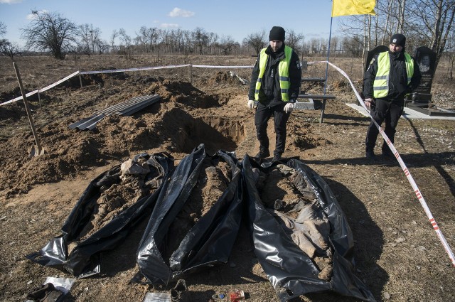 Zdjęcie zrobione 2 marca. Ukraińscy policjanci ekshumują trzy ciała osób, które zginęły podczas rosyjskiej okupacji miasta Borodjanka na Ukrainie. Ciała zostały pochowane przez mieszkańców „około 08 marca 2022 r.” - powiedział szef policji obwodu kijowskiego Andrij Niebytow