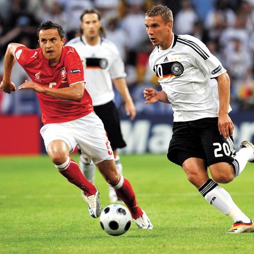Lukas Podolski (z prawej) w wyścigu do piłki z Dariuszem Dudką.