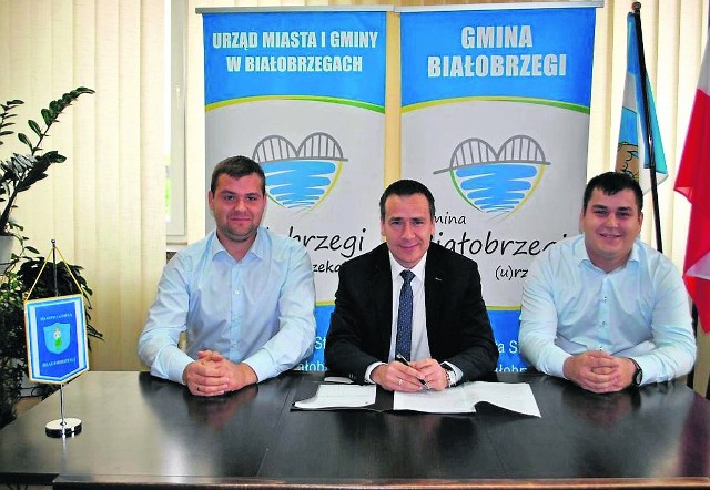 W piątek podpisano akt sprzedaży działki. Na zdjęciu: burmistrz Adam Bolek i przedstawiciele GIM Michał i Adam Greliak.