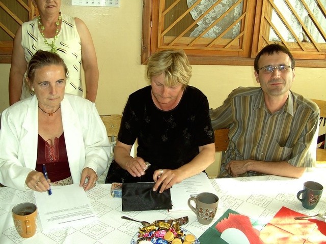 Lidia Rosołowicz (skarbnik), Iwona Szweda (prezes) oraz Artur Michalak (sekretarz) ze Stowarzyszenia Inicjatyw Rozwoju Rynarzewa podpisują umowę na realizację projektów.
