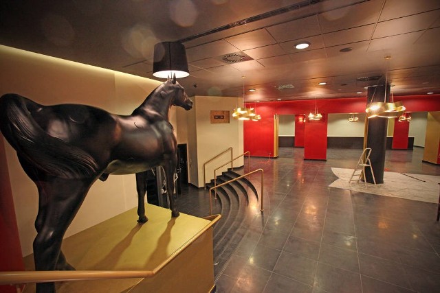 Złotoczerwone foyer wygląda imponująco, jest strzeżone przez rzeźbę konia z abażurem
