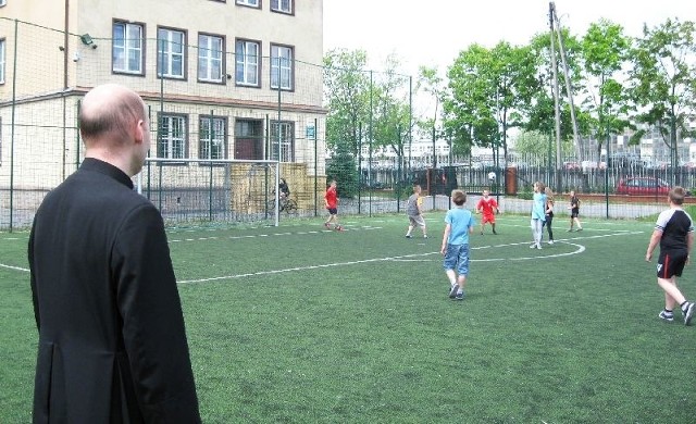 Ksiądz Łukasz Zieliński podczas lekcji religii na boisku