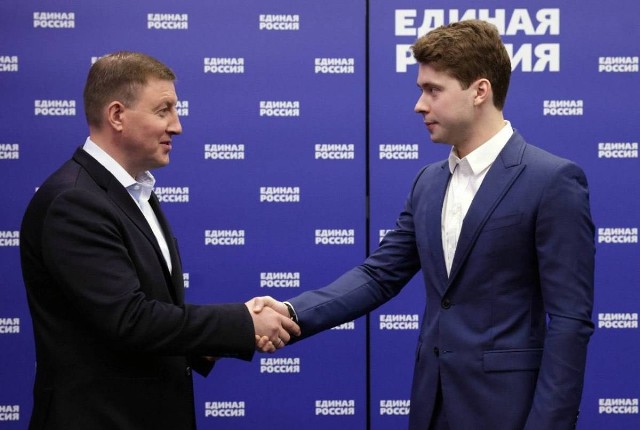 Ilja Miedwiediew (po prawej) tuż po otrzymaniu legitymacji członkowskiej partii "Jedna Rosja" przyjmuje gratulacje od sekretarza Rady Generalnej tego ugrupowania Andreja Turczaka