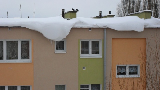 Przy ulicy Broniewskiego 1 z dachu tego budynku zwisa potężny "płaszcz" zbrylonego śniegu.