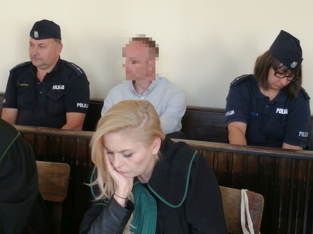 35-letni Kamil C., czyli główny oskarżony, który usłyszał aż 20 zarzutów, na ławie oskarżonych pilnowany przez policjantów.