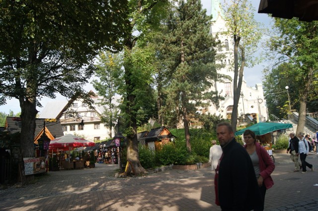 Ksiądz planuje galerię tam, gdzie stoją kramy (po lewej). To ścisłe sąsiedztwo kościoła (za drzewami)