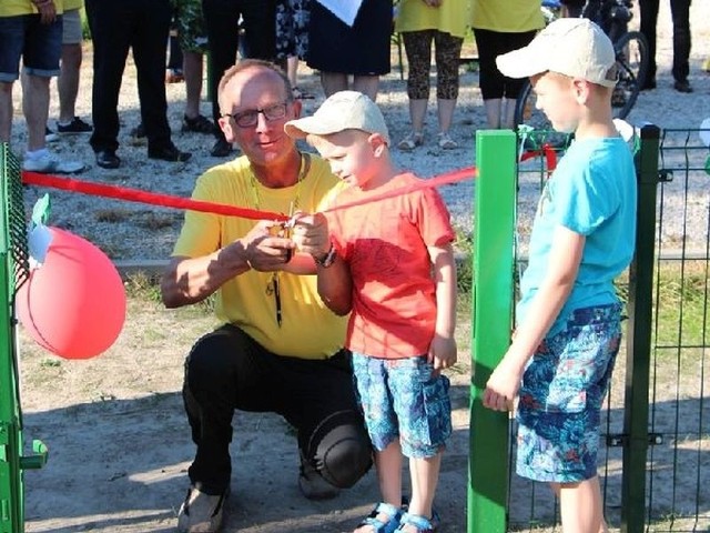 Sołtys Stefanówka Jacek Maruszewski przecina wstęgę otwierającą plac zabaw