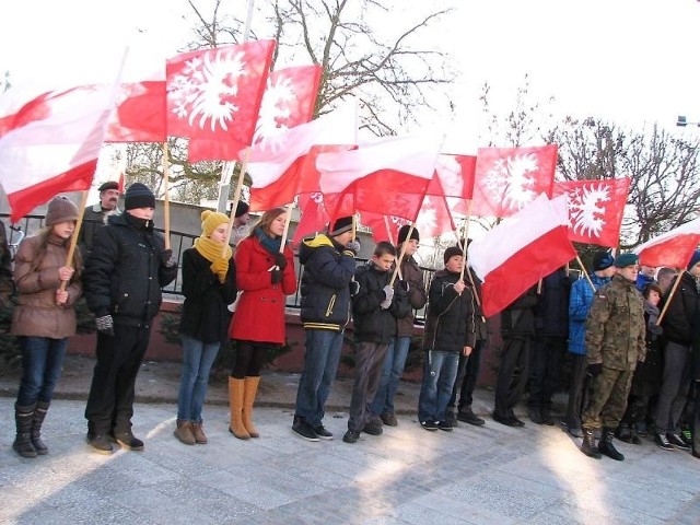 Uczniowie szkoły trzymali w dłoniach flagi narodowe i powstańcze