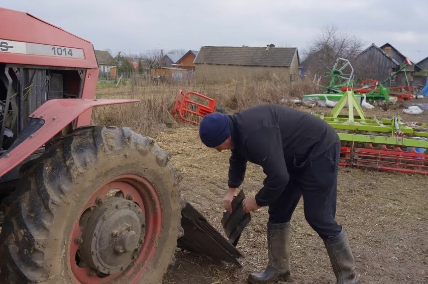 Andrzej montuje osłony silnika w wyremontowanym ciągniku