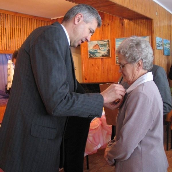 Wiesław Ordon przypina medal przyznany przez Prezydenta RP jednej z małżeńskich par.