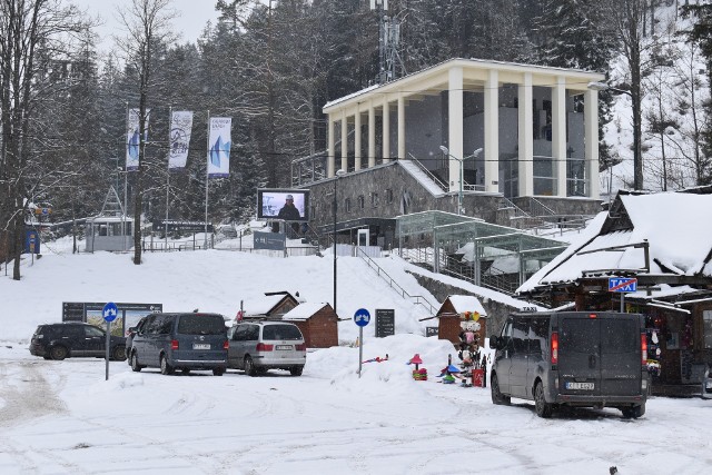 Plac w Kuźnicach - na pierwszym planie post&oacute;j bus&oacute;w, a w tle dolna stacja kolejki na Kasprowy Wierch