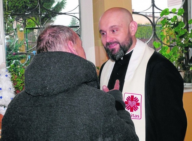 Ksiądz Damian Drabikowski, wicedyrektor radomskiej Caritas w opłatkowej rozmowie z jednym z podopiecznych jadłodajni.