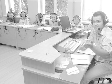 Łukasz Krawczyk, nauczyciel języka niemieckiego i dzieci ze Szkoły Podstawowej nr 4 prezentują możliwości nowej, multimedialnej  pracowni językowej